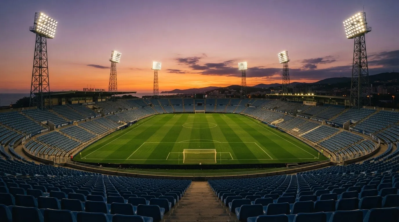 Un estadio de fútbol vacío con torres de iluminación al atardecer